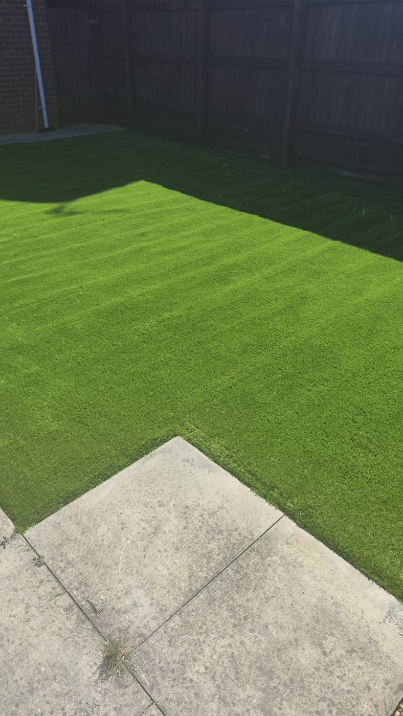 Artificial grass lawn meeting a paving edge cleanly