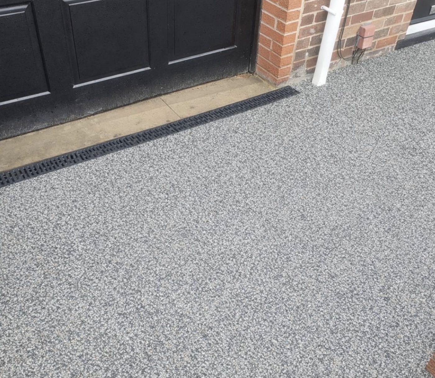 Resin bound driveway with a channel drain across the threshold